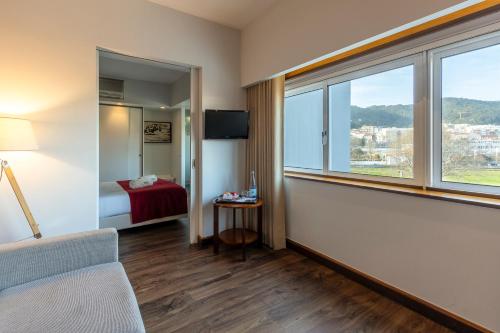 a hotel room with a bed and a window at Hotel Rali Viana in Viana do Castelo