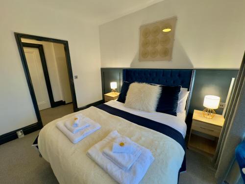 a bedroom with a bed with two towels on it at Coastal Park Accommodation in Llanelli