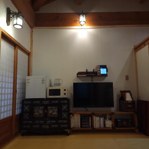 a living room with a flat screen tv on the wall at Hanok Hyeyum in Jeonju