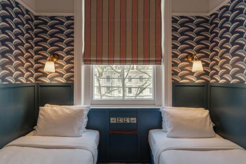 two beds in a room with a window at St. David's Hotels Paddington in London