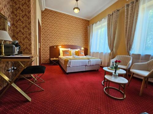 a hotel room with a bed and a red carpet at Hotel Galicja SPA Wieliczka in Wieliczka