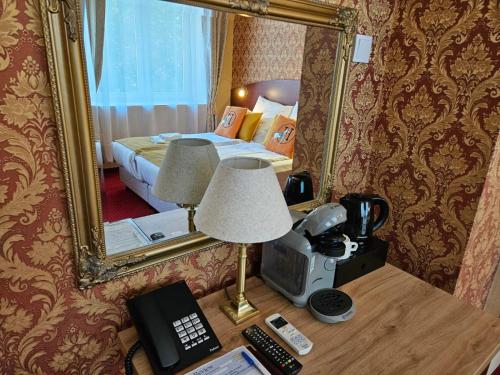a hotel room with a bed and a mirror at Hotel Galicja SPA Wieliczka in Wieliczka