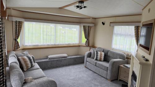 a living room with two couches and a tv at Coastal Caravan in Solva in Haverfordwest