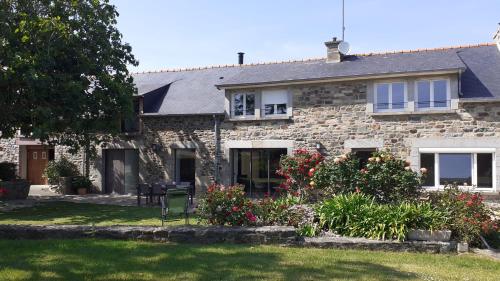une maison en pierre avec des fleurs dans la cour dans l'établissement Le Refuge Marin, à Dahouet