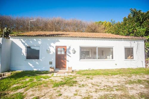 a white house with a door in a yard at Lisbon Countryside - Serenity Near the City in Calhandriz