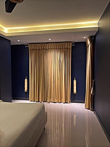a bedroom with a bed and a curtain at Regal Suite by StayMehman in Rawalpindi