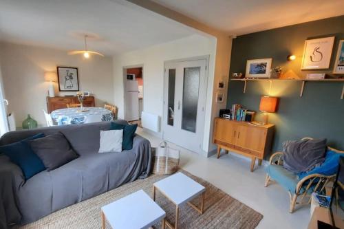 un salon avec un canapé et une table dans l'établissement L'idéale, 500m du port de Kerity, 3 chb, 6 personnes, à Penmarcʼh