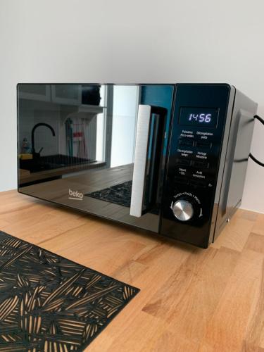 - un four micro-ondes installé au-dessus du parquet dans l'établissement Appartement au calme proche château de Launac, animaparc, à Launac