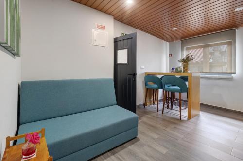 a living room with a couch and a kitchen with a counter at Casa Da Capela in Entre Ambos os Rios