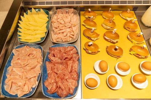 a tray filled with different types of breakfast foods at Hotel Columbia in Marina Romea