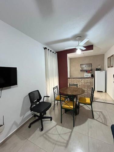 Una sala de estar con mesa y sillas y una cocina. en Ap Aconchegante Catanduva II, en Catanduva