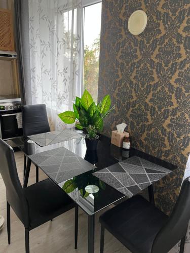 a dining room table with two chairs and a plant on it at Central Cosy-Turistu Mitne in Daugavpils