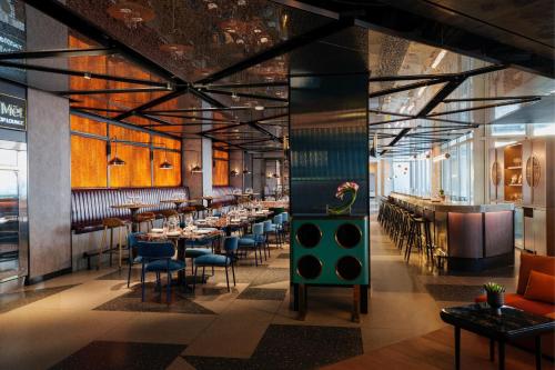 a restaurant with tables and chairs and a bar at Renaissance New York Flushing Hotel at Tangram in Queens
