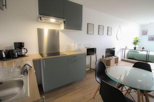 une cuisine avec une table et un comptoir dans l'établissement NEW La Casa 1 grand studio rénové, Wifi, à Angoulême