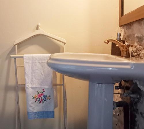 un bagno con lavandino e un asciugamano sullo scaffale di Suite en cuadra pajar, casa Rural a Hoz de Jaca