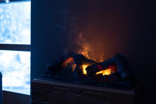 a fireplace with a fire in it next to a window at Hotel Promyk Wellness & Spa in Karpacz