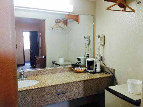 La salle de bains de l'hôtel est pourvue d'un lavabo et d'un miroir. dans l'établissement Economy Inn, à San Francisco