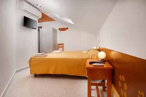 a small bedroom with a bed and a table at Sierra de Arbe in Naval