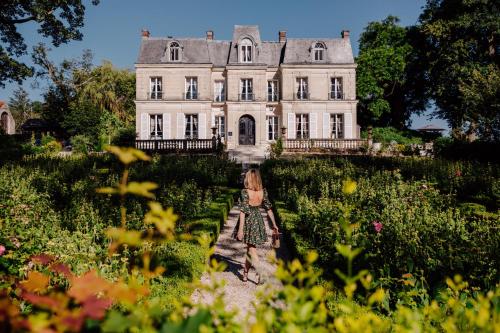 a woman in a garden in front of a house at Château de Picheny in Picheny