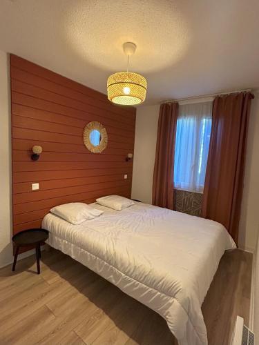 une chambre avec un grand lit et un lustre dans l'établissement Souleih d Ossau 203, à Bielle