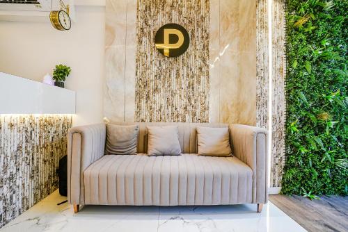 a couch in a living room with a green wall at FabHotel Peralz - Nr Boriwali Station in Mumbai