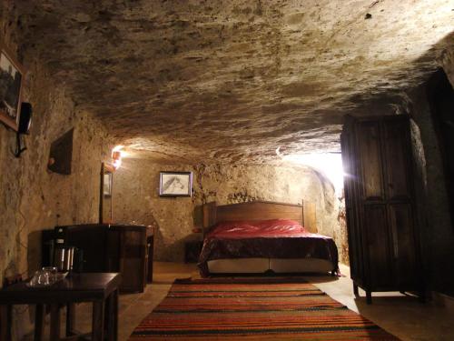 a bedroom with a bed in a stone room at Kapadokya Ihlara Konaklari & Caves in Guzelyurt