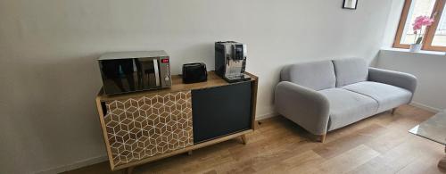 un salon avec une télévision et une chaise dans l'établissement F3 centre ville Baume les dames, à Baume-les-Dames