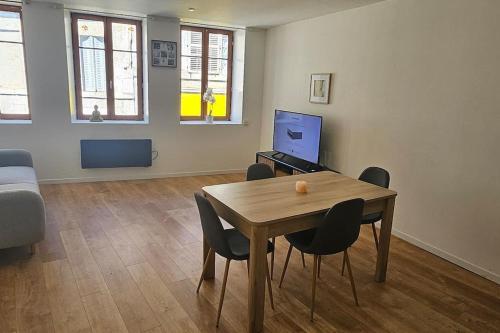 un salon avec une table et des chaises en bois dans l'établissement F3 centre ville Baume les dames, à Baume-les-Dames