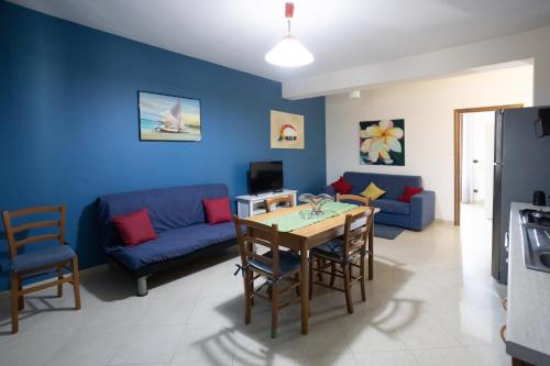 a living room with a blue couch and a table at Etna Case Mangano in Linguaglossa