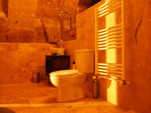 a bathroom with a white toilet and a sink at Kapadokya Ihlara Konaklari & Caves in Guzelyurt