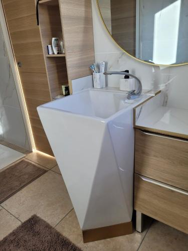 une salle de bain avec un lavabo blanc et un miroir dans l'établissement Villa climatisée 6 personnes, à Pia