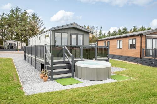 an rv with a hot tub in a yard at Lodge No 83 - Stewart's Resort Cameron in St. Andrews