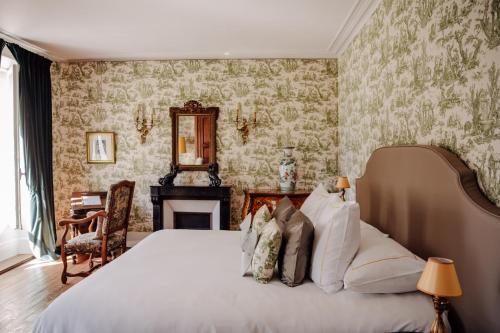 a bedroom with a large bed and a fireplace at Château de Picheny in Picheny