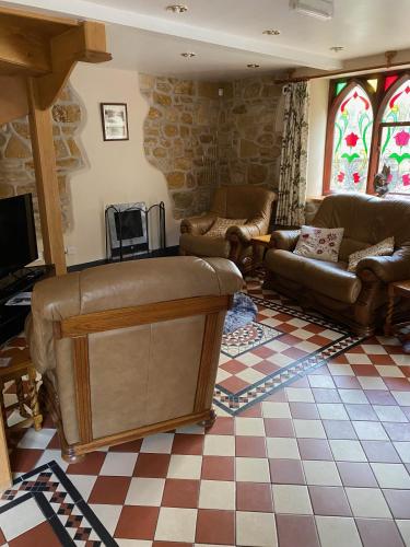 a living room with a couch and a fireplace at The School House, Ironbridge in Ironbridge