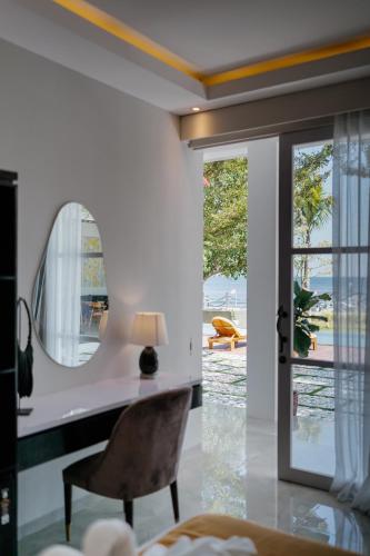 a room with a mirror and a chair and a table at Muara Lovina Hotel in Singaraja