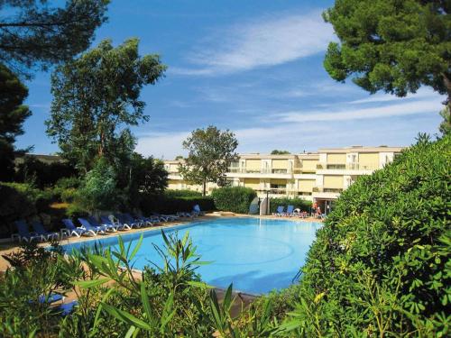 une grande piscine avec des chaises et un bâtiment dans l'établissement La Corniche d'Or à St Raphael, à Saint-Raphaël