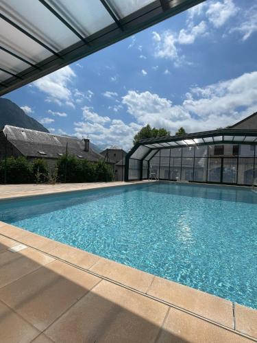 une grande piscine avec une maison en verre dans l'établissement Souleih d Ossau 203, à Bielle