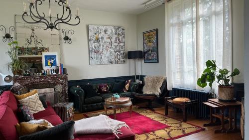 a living room with a couch and a table at Le Domaine de Blanvatel in Sainte-Marguerite-de-Viette