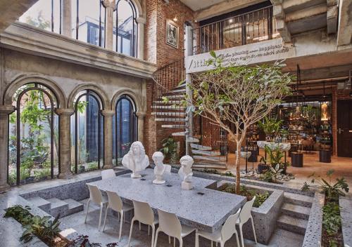 a table and chairs in a room with a building at Cataleya Estate Boutique Bed & Breakfast in Bangkok