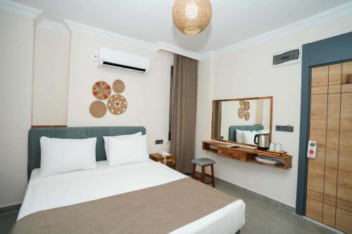a hotel room with a bed and a mirror at Port Selene Otel in Kışlabucağı