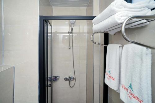 a shower in a bathroom with white towels at Port Selene Otel in Kışlabucağı