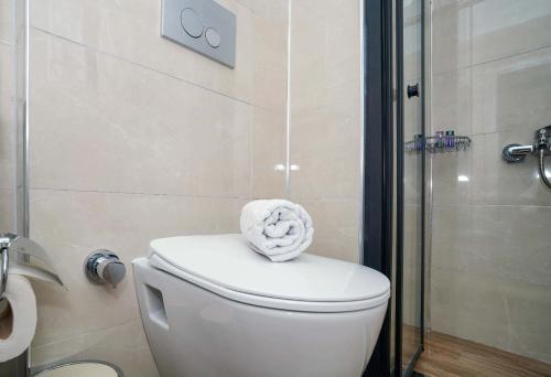 a bathroom with a toilet with a towel on it at Port Selene Otel in Kışlabucağı