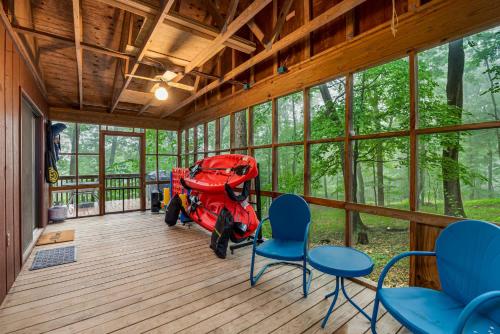 a red scooter parked in a room with chairs at River Cabin w Great Views, Screened Porch & Fire Pit in Great Cacapon
