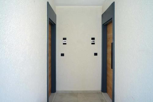 a hallway with two doors with squares on the wall at Port Selene Otel in Kışlabucağı