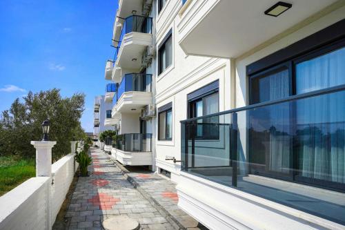 a building with large windows and a sidewalk at Port Selene Otel in Kışlabucağı
