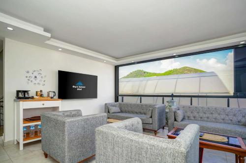 a living room with couches and a large screen at Port Selene Otel in Kışlabucağı