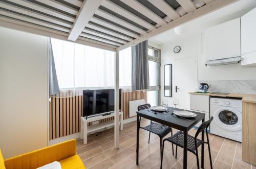 une cuisine et un salon avec une table et des chaises dans l'établissement Close to Montmartre l Fully equipped studio, à Paris