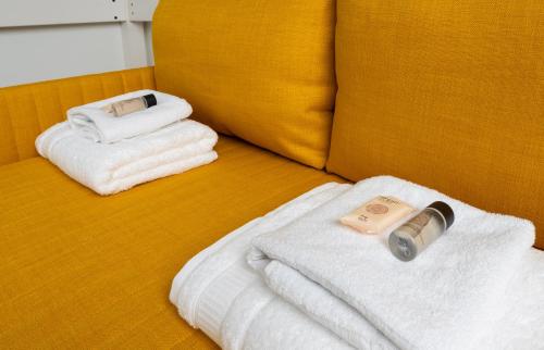 - un lit avec des serviettes et une bouteille de savon dans l'établissement Close to Montmartre l Fully equipped studio, à Paris