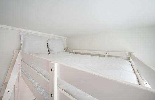 Ce lit superposé blanc se trouve dans une chambre blanche. dans l'établissement Close to Montmartre l Fully equipped studio, à Paris