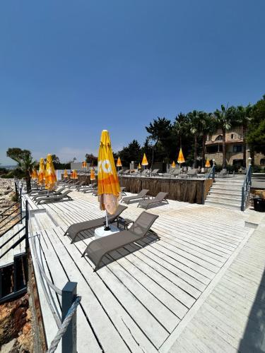 a group of lounge chairs with umbrellas on a beach at Casalita Hotel in Kizkalesi